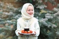 Charming girl in Russian chalet holding a plate with Easter eggs